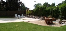 Plage piscine traditionnelle dallée et terrasse bois - 